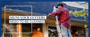 man on ladder cleaning gutter